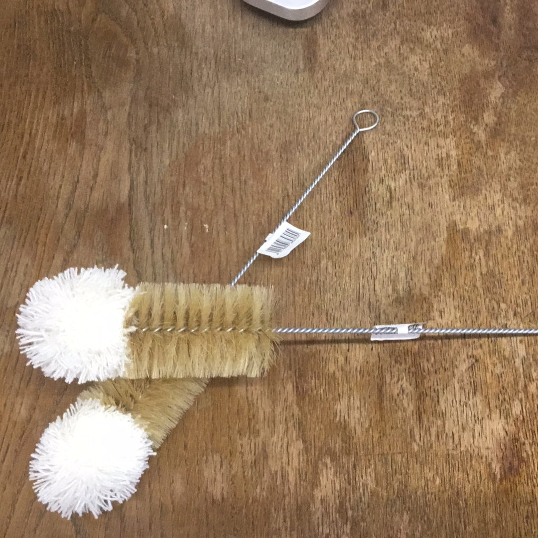 A bottle brush with natural fibers, featuring a wooden handle and white bristles with a product label attached.