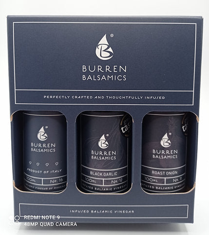 A gift box containing three 100ml bottles of Burren Balsamics, with labels indicating the flavors: Balsamic Vinegar of Modena, Black Garlic, and Roast Onion.