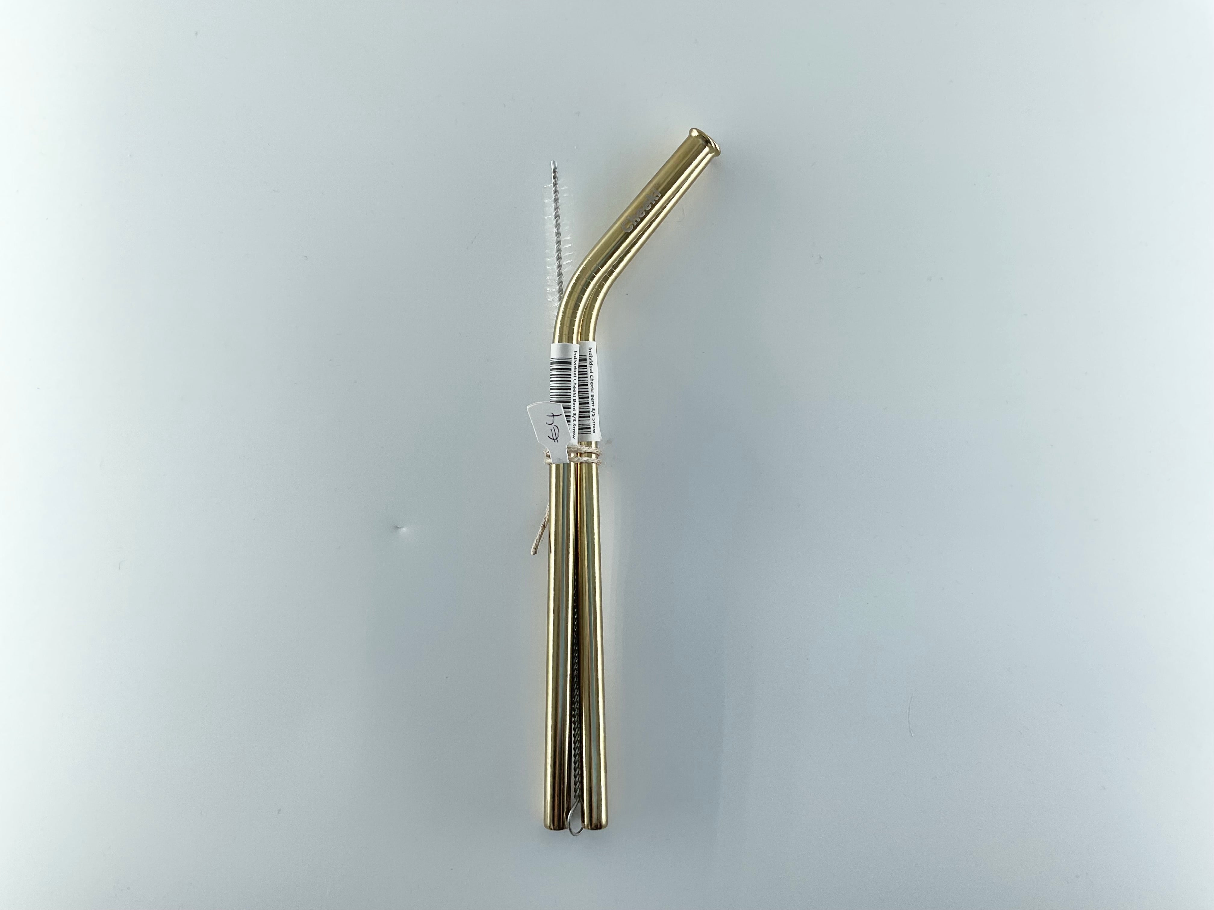 Gold metal straw with a clear label on a light gray background