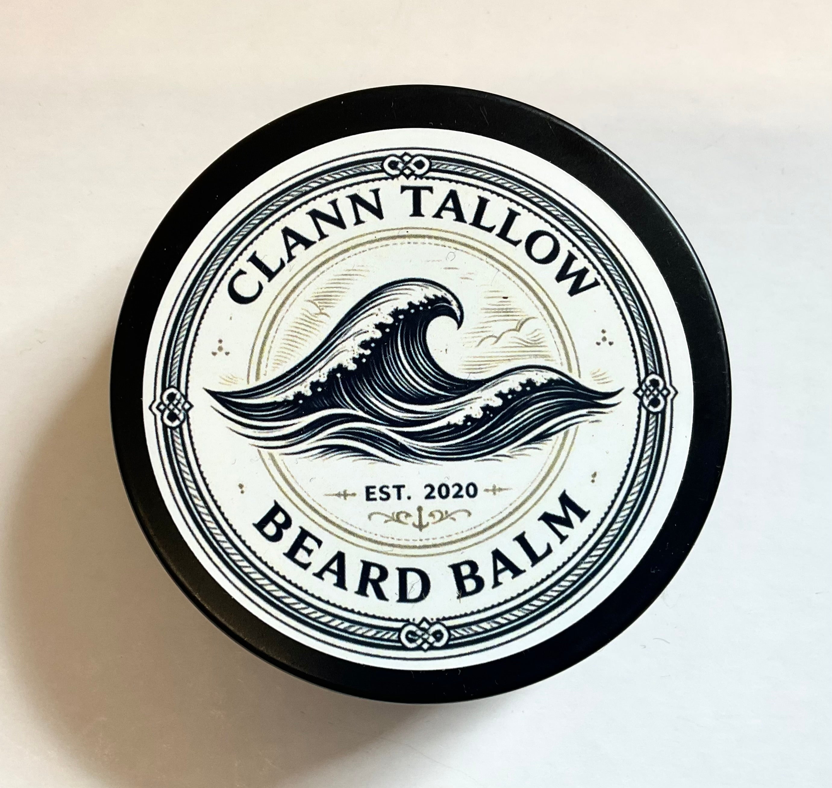 Clann Tallow beard balm container with wave design on a beige background