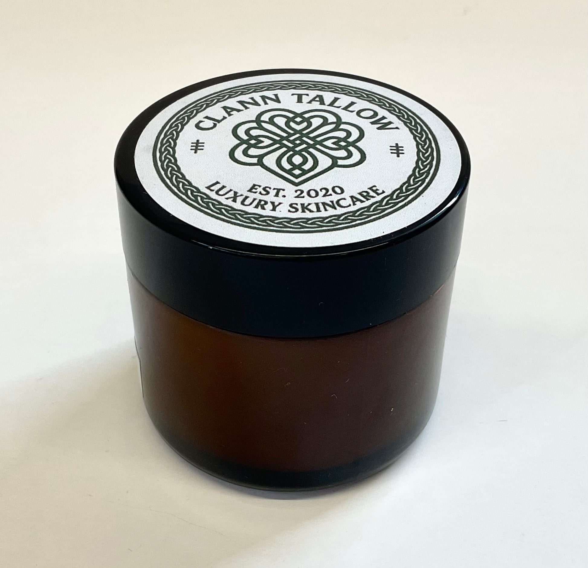 Brownglass  jar with black lid featuring 'Clann Tallow Luxury Skincare' on a white background