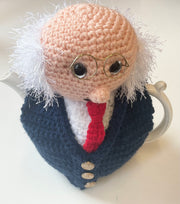 Crocheted tea cozy with a face design on a white background