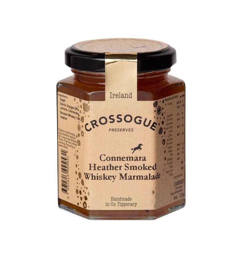 A hexagonal glass jar of Crossogue Connemara Heather Smoked Whiskey Marmalade on a plain white background. The jar has a black lid with a gold seal and a tan label featuring the brand name and product details.