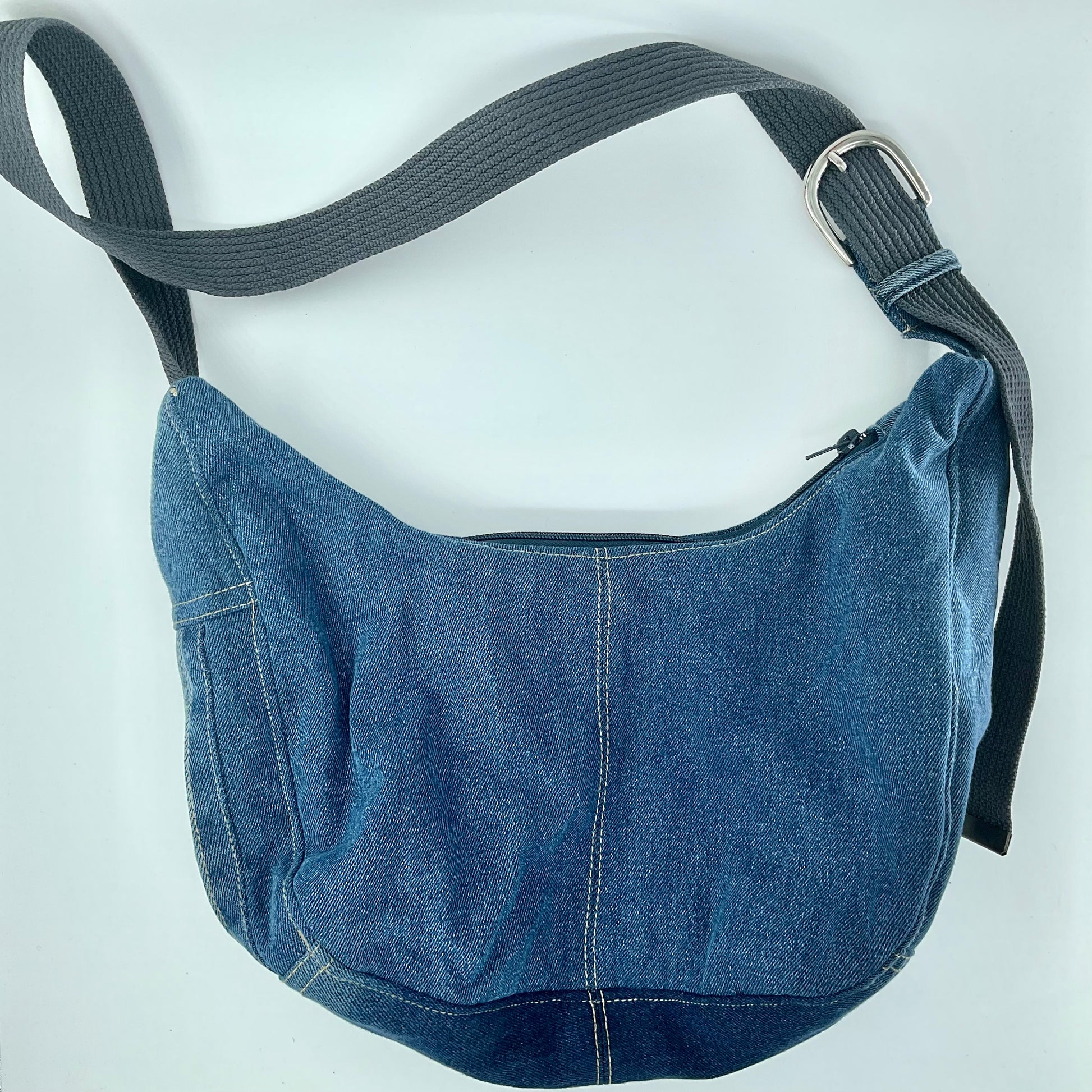 Blue denim bag with a strap on a white background