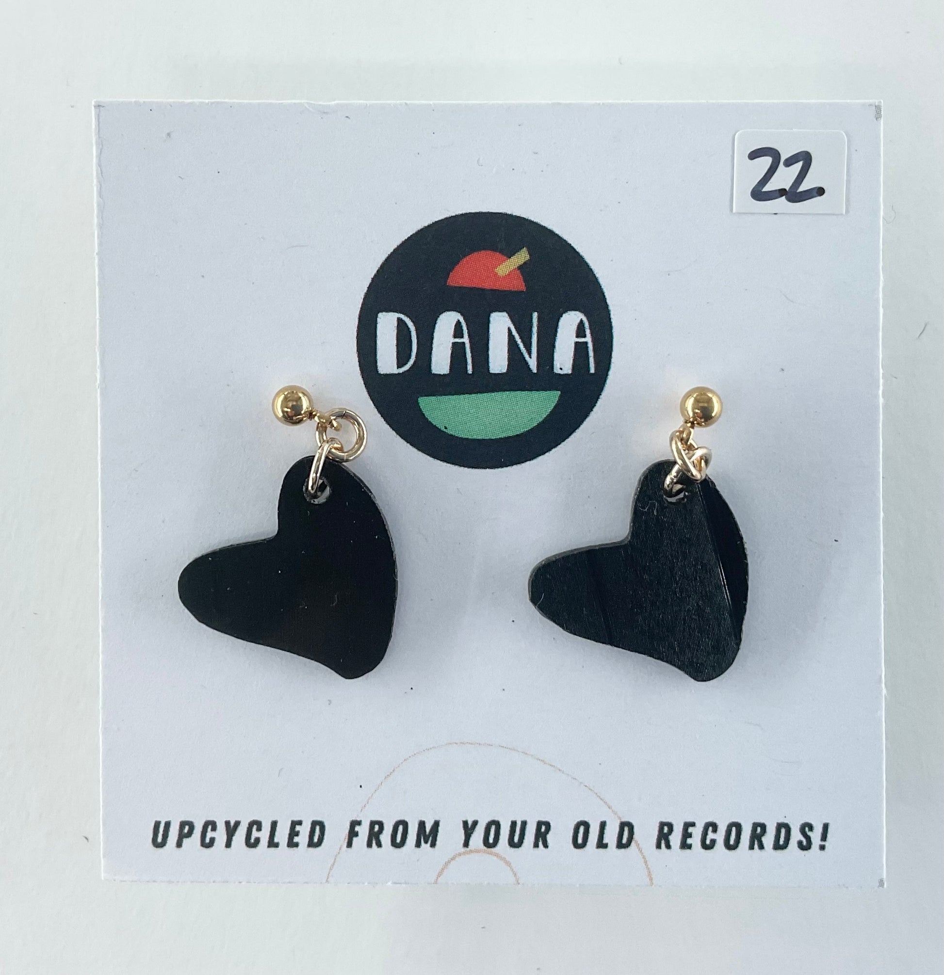 Black heart-shaped earrings on a Dana branded card with 'Upcycled from your old records!' text.