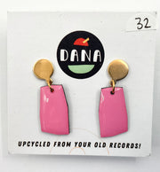 A pair of pink earrings with metallic details, displayed on a card with the Dana Jewellery brand logo and text 'UPCYCLED FROM YOUR OLD RECORDS!'.