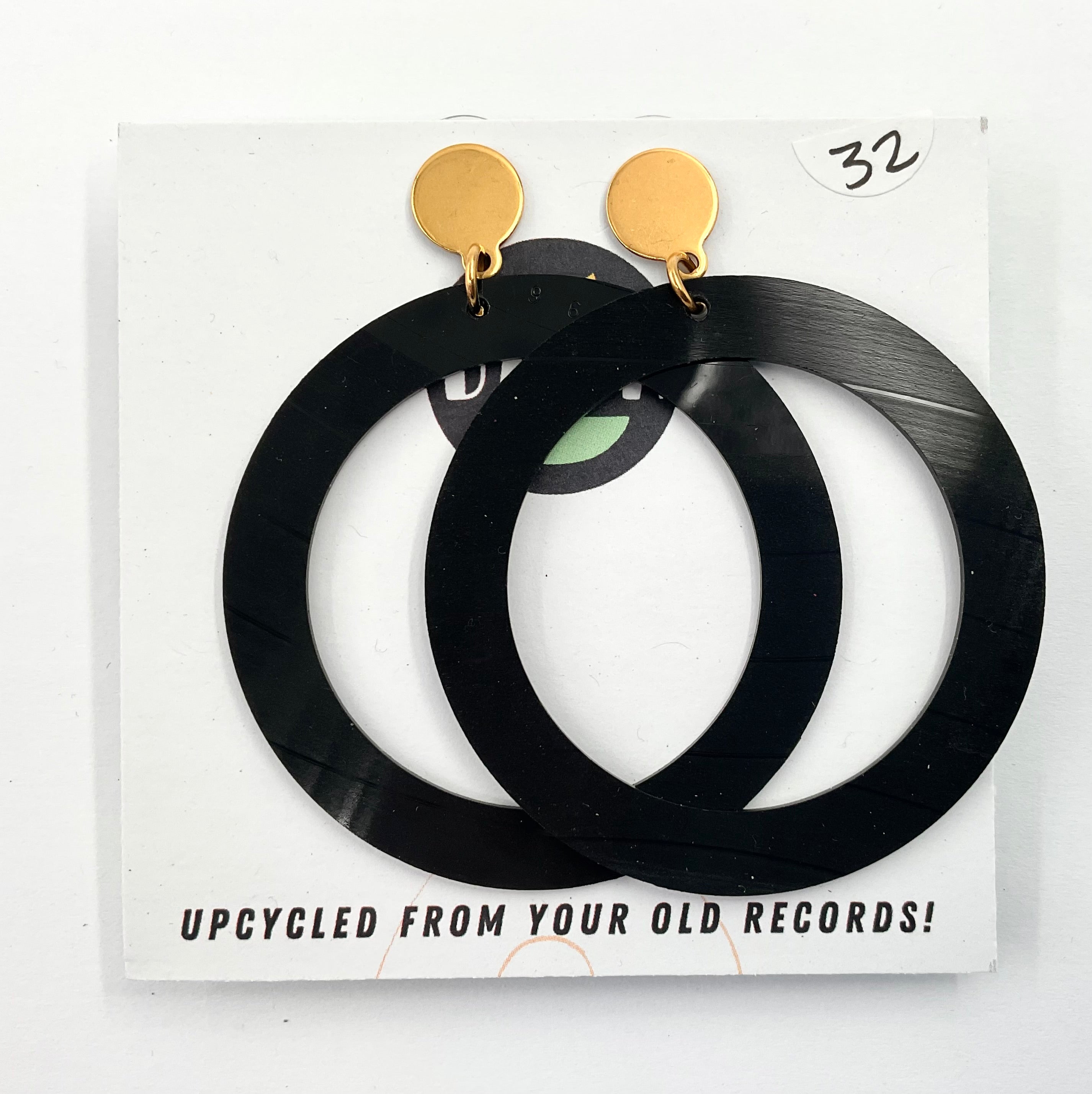 A pair of large black hoop earrings made from upcycled vinyl record, displayed on a white background with the text 'UPCYCLED FROM YOUR OLD RECORDS!'