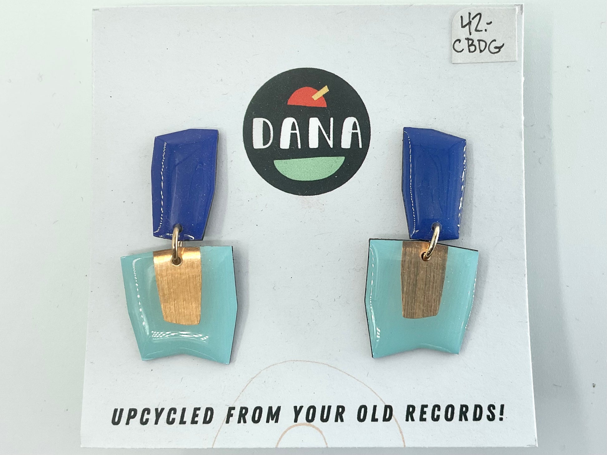 A pair of blue and turquoise earrings made from upcycled vinyl records, displayed on a card with the brand name 'DANA'.