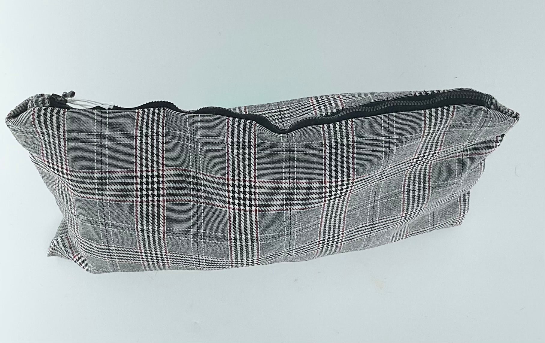 Gray plaid pouch with a zipper on a light gray background