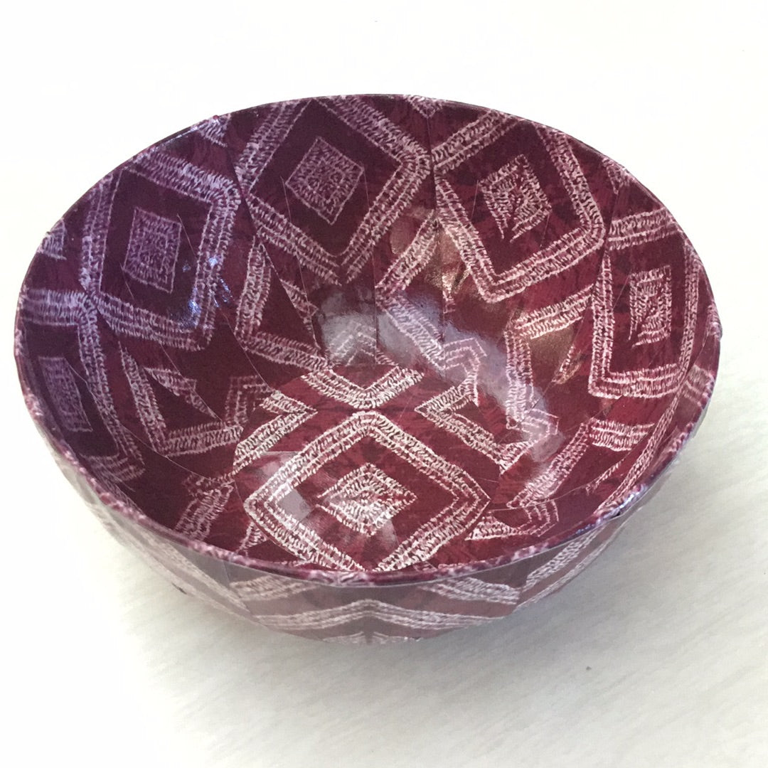 a paper mache bowl with red and white patterns