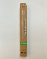 A Humble Brush brand toothbrush with a bamboo handle, packaged in an eco-friendly cardboard box with recycled materials.