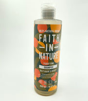 A bottle of FAITH IN NATURE shampoo with a label featuring orange and grapefruit graphics, indicating the scent of the product.