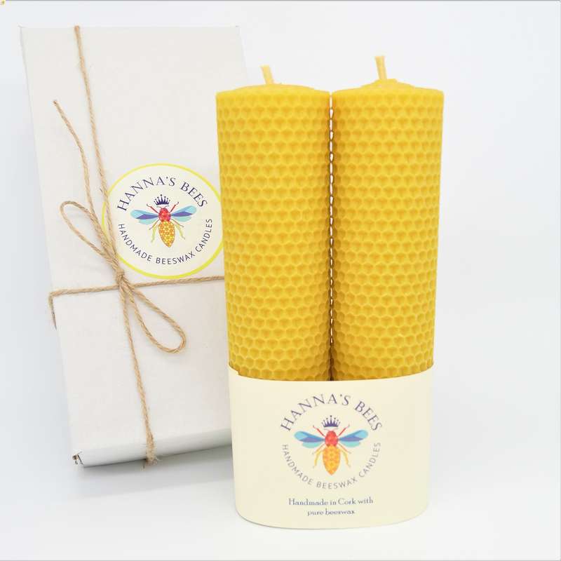 Yellow beehive-patterned candle with 'Hanna's Bees' branding on a white background