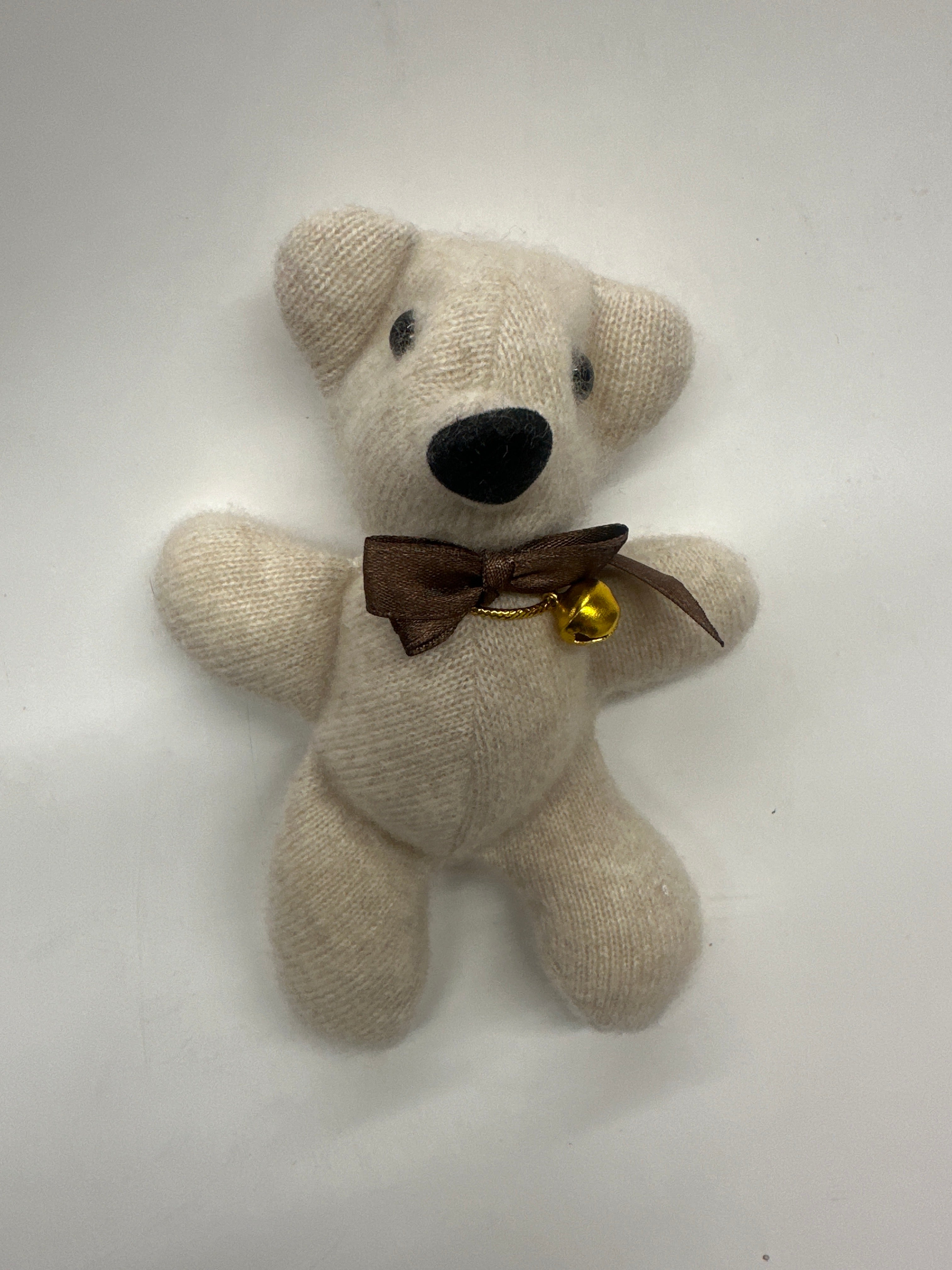 Stuffed teddy bear with a brown bow tie on a white background