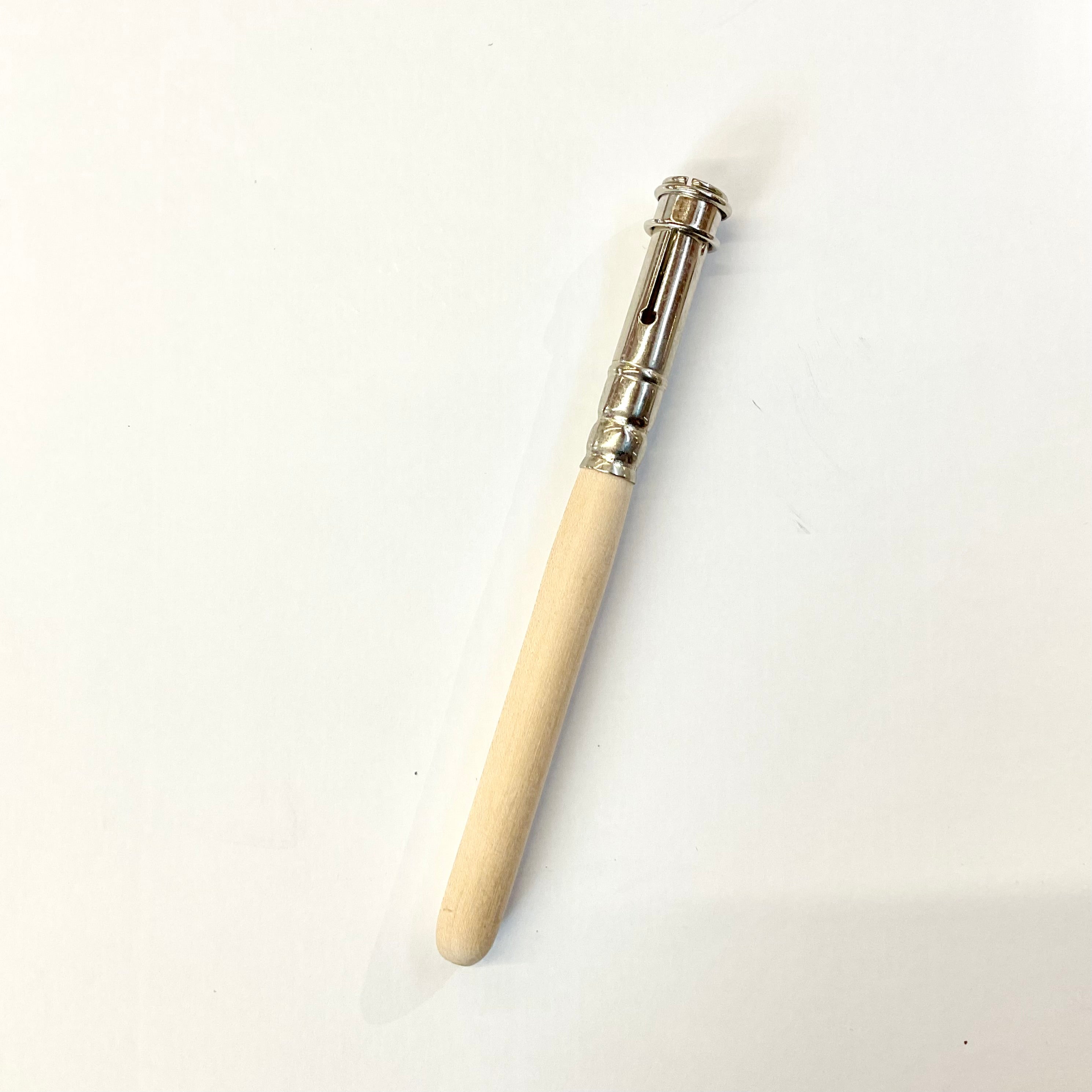 A beige-colored wooden pencil extender with a metal tip on one end, placed against a white background.
