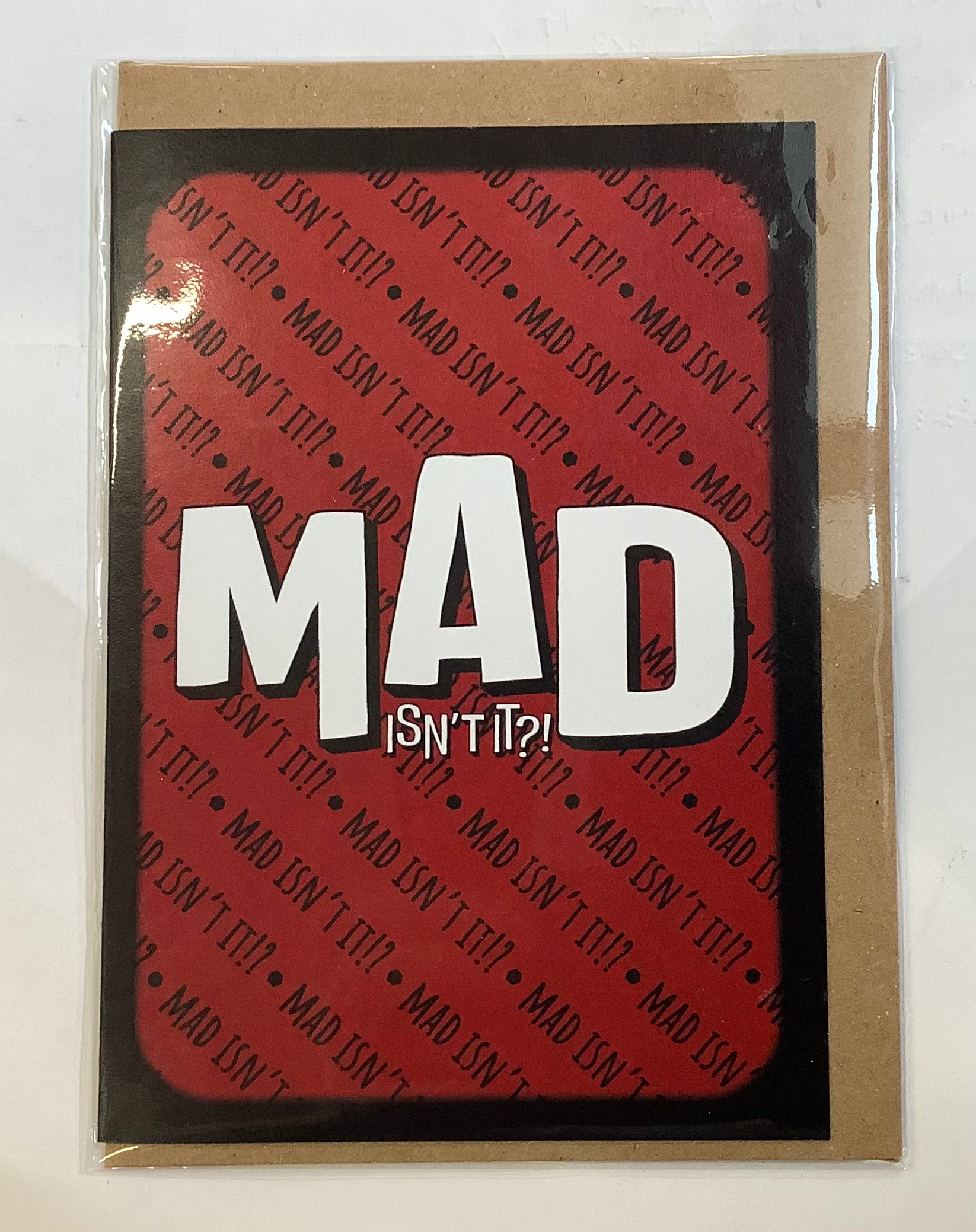 Card with white 'MAD isn't it?' text on a red background with the same wording in small repeated on the background