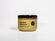 Jar of roasted pistachio caramelly spread on a white background