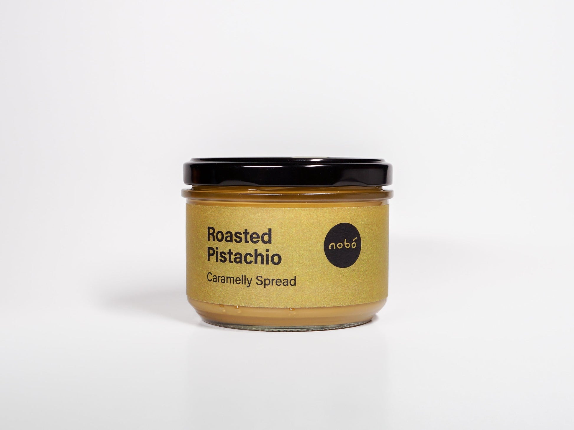 Jar of roasted pistachio caramelly spread on a white background