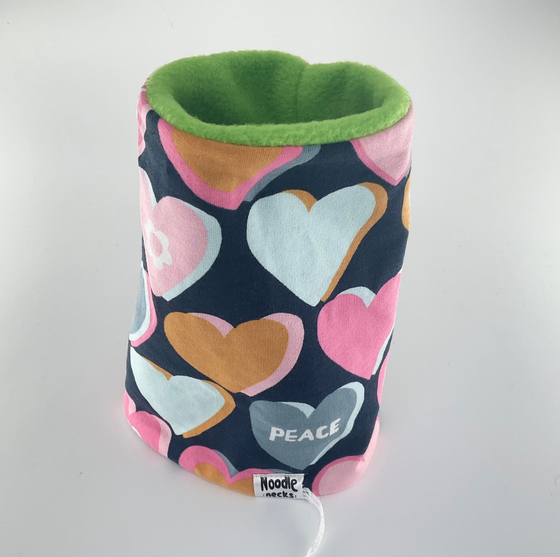 Cylindrical fabric container with heart pattern and green rim on a white background