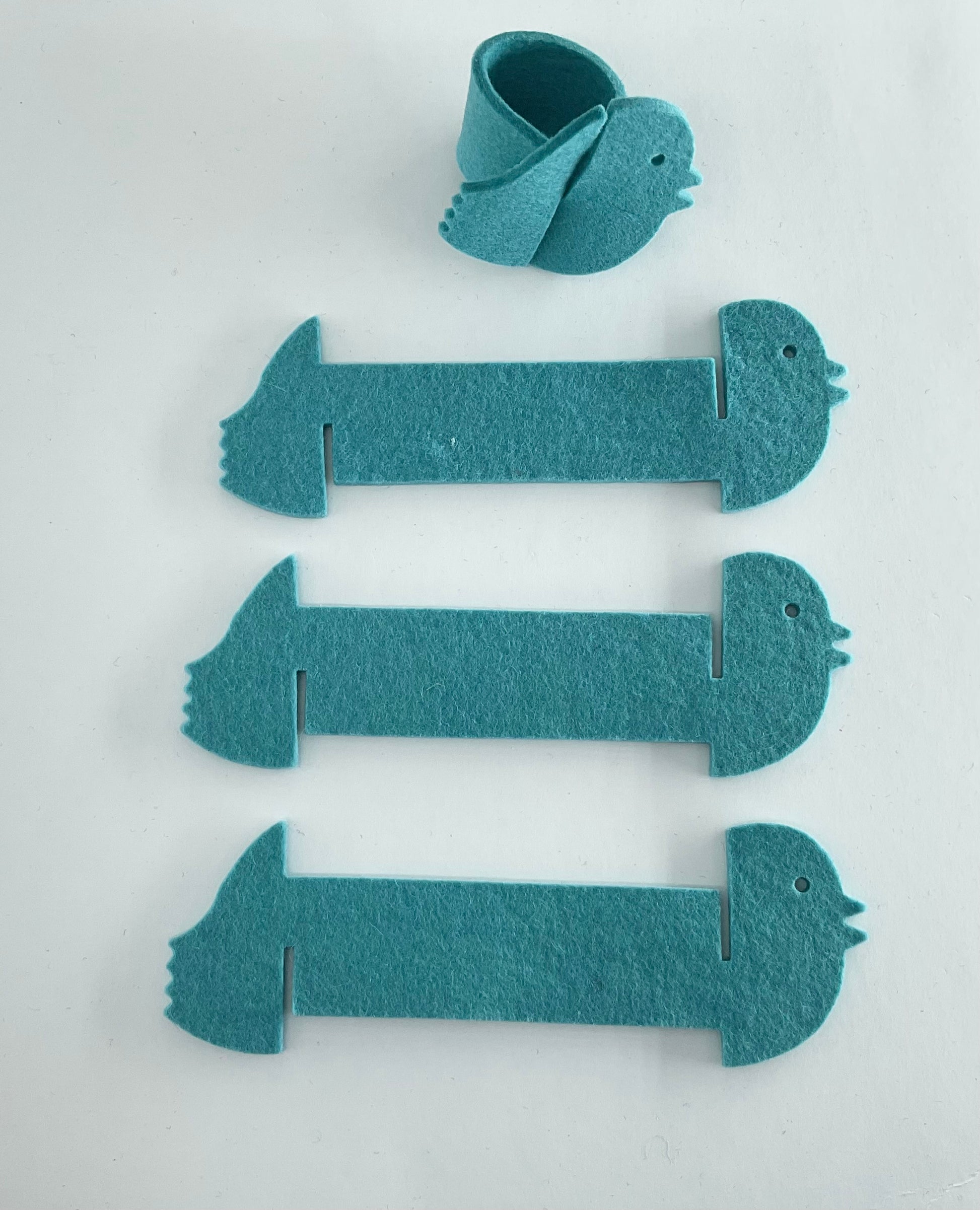 Set of blue felt bird napkin holders on a white background