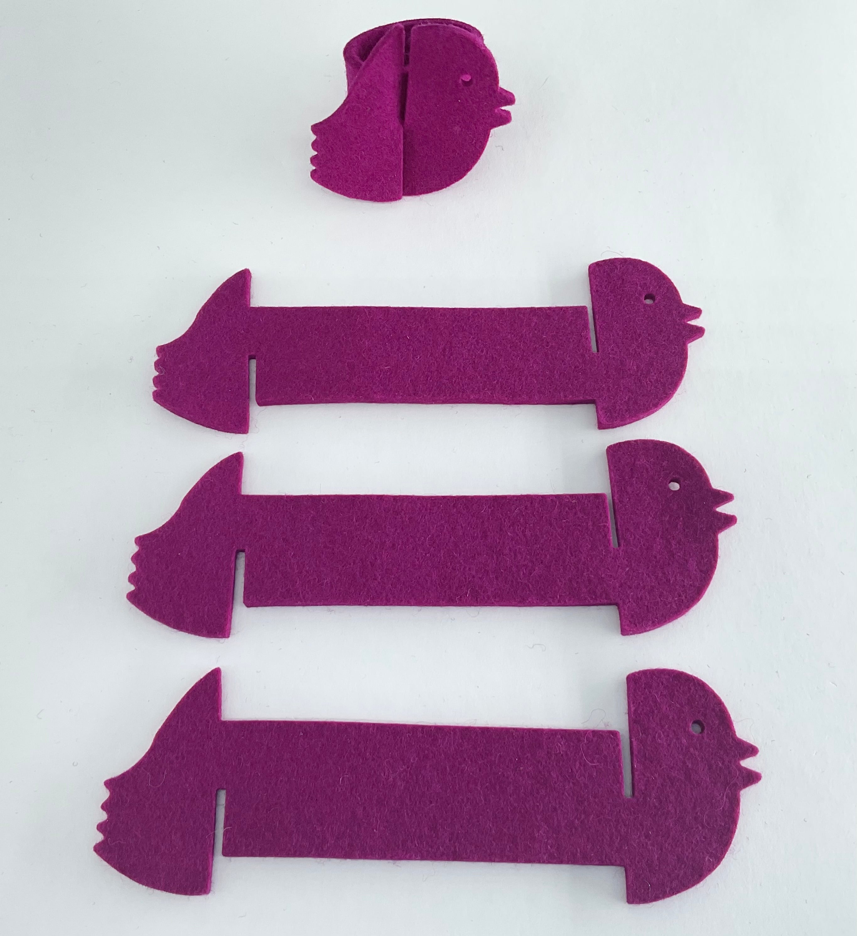 Purple felt bird napkin holders on a white background