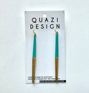Teal and gold earrings on a Quazi Design card against a white background