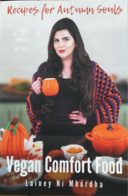 A book cover for 'Recipes for Autumn Souls' featuring a woman holding a mug with a colorful blanket in the background, and various kitchen items like pumpkins and a teapot.