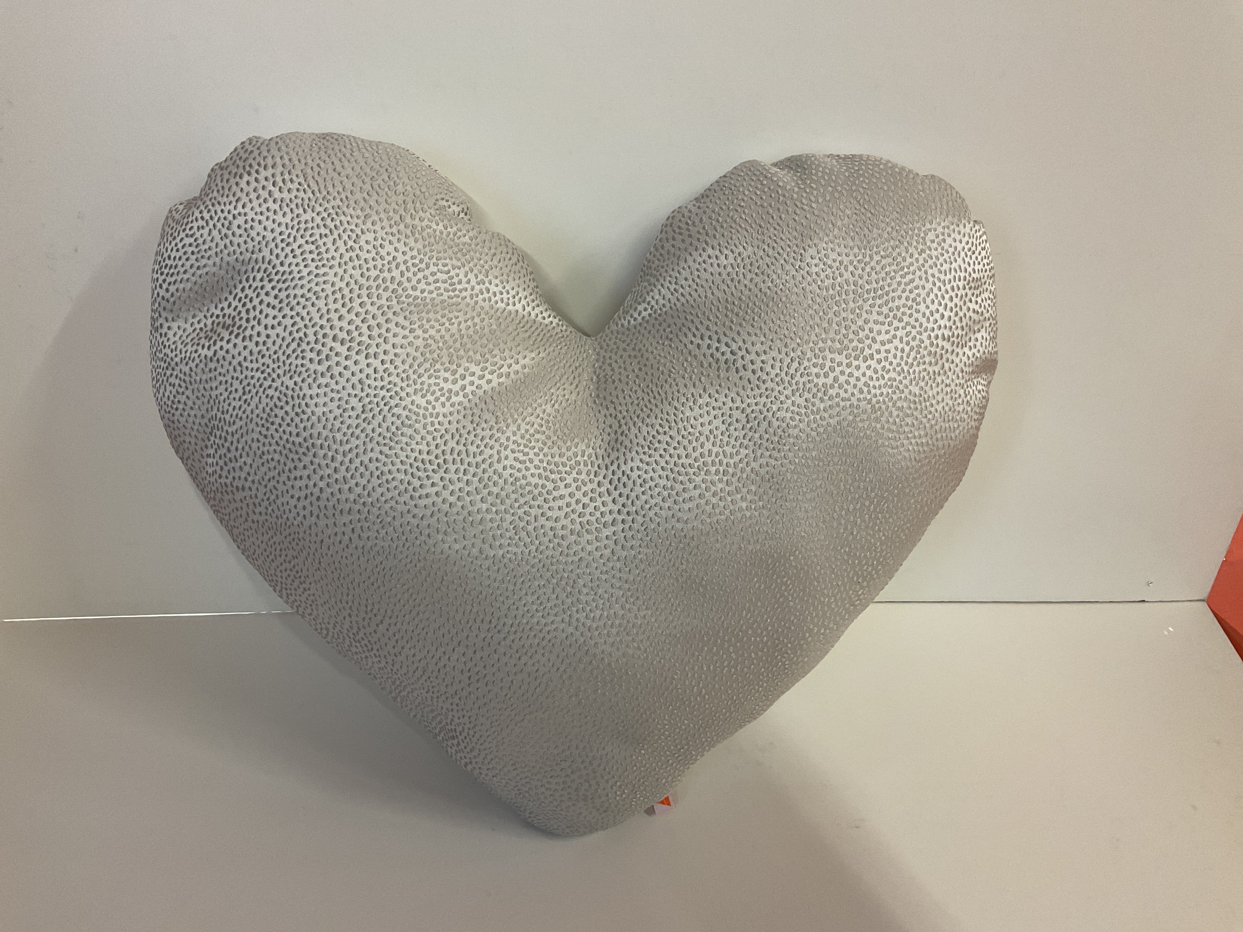 Heart-shaped pillow with a textured surface on a white background