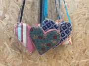 Heart-shaped fabric pouches with floral patterns on a wooden surface