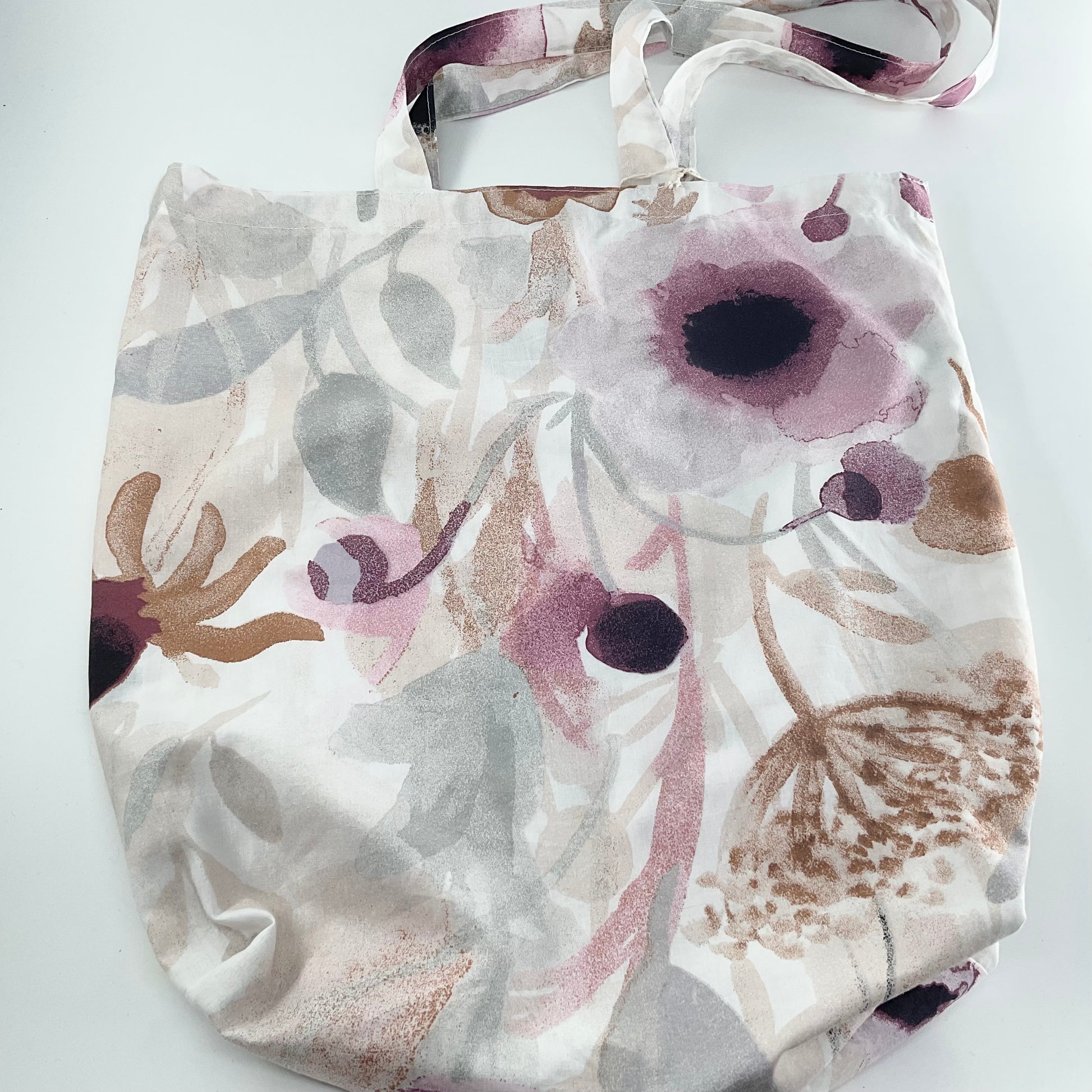 Floral-patterned fabric with purple and brown flowers on a white background