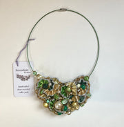 Necklace with green and gold beads on a white background