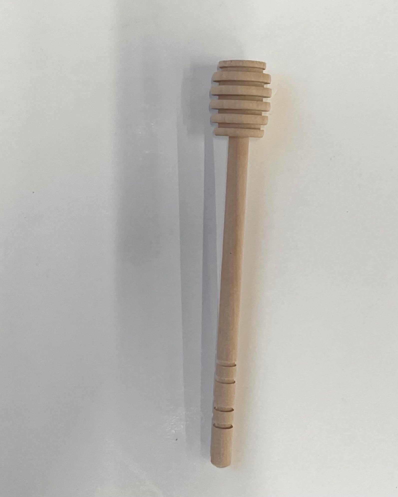 Wooden honey dipper on a white background