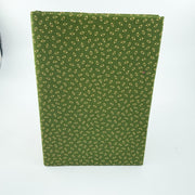 A green notebook or journal with a small repeating floral pattern, standing upright on a white background.