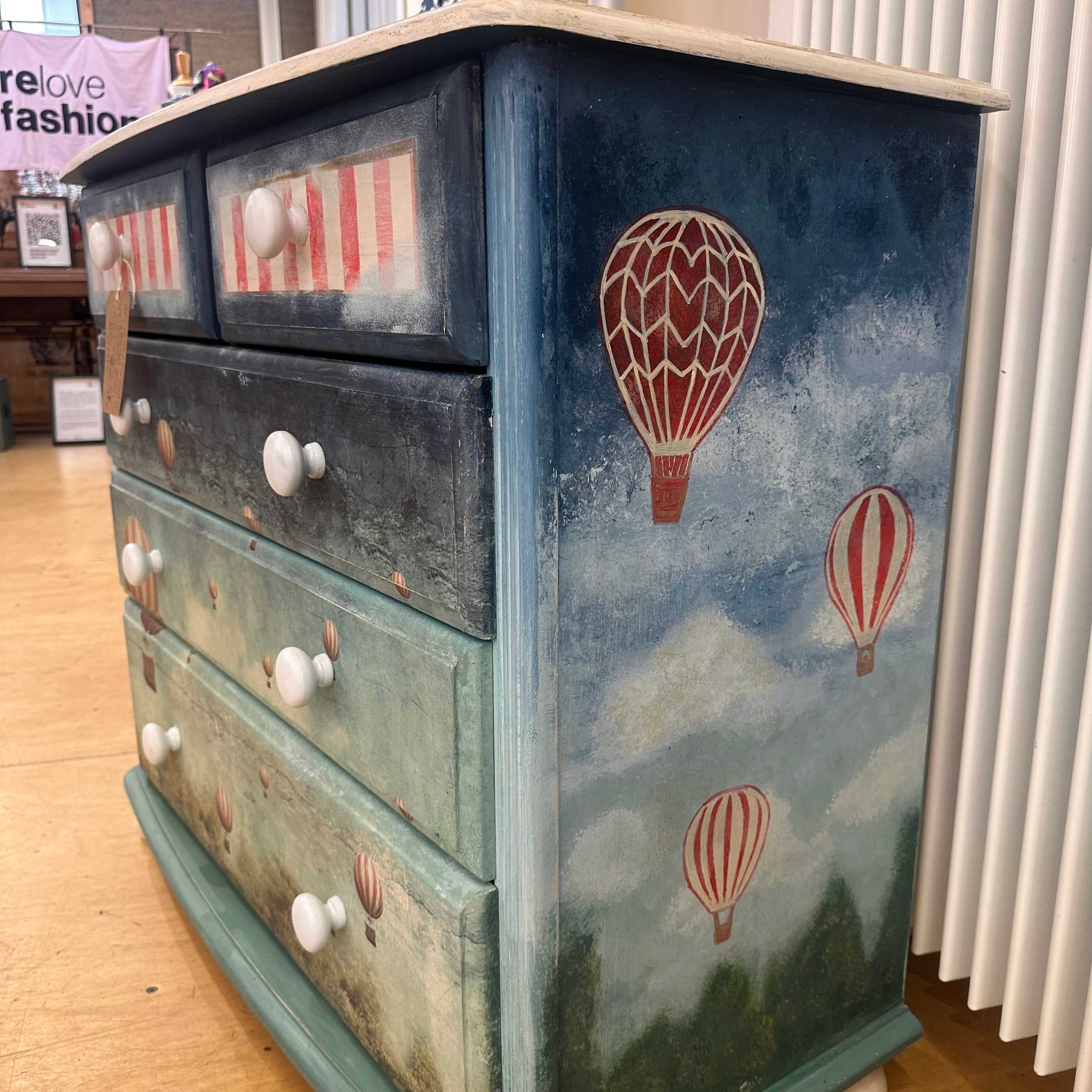 Wooden dresser with hot air balloon design on a blue sky background