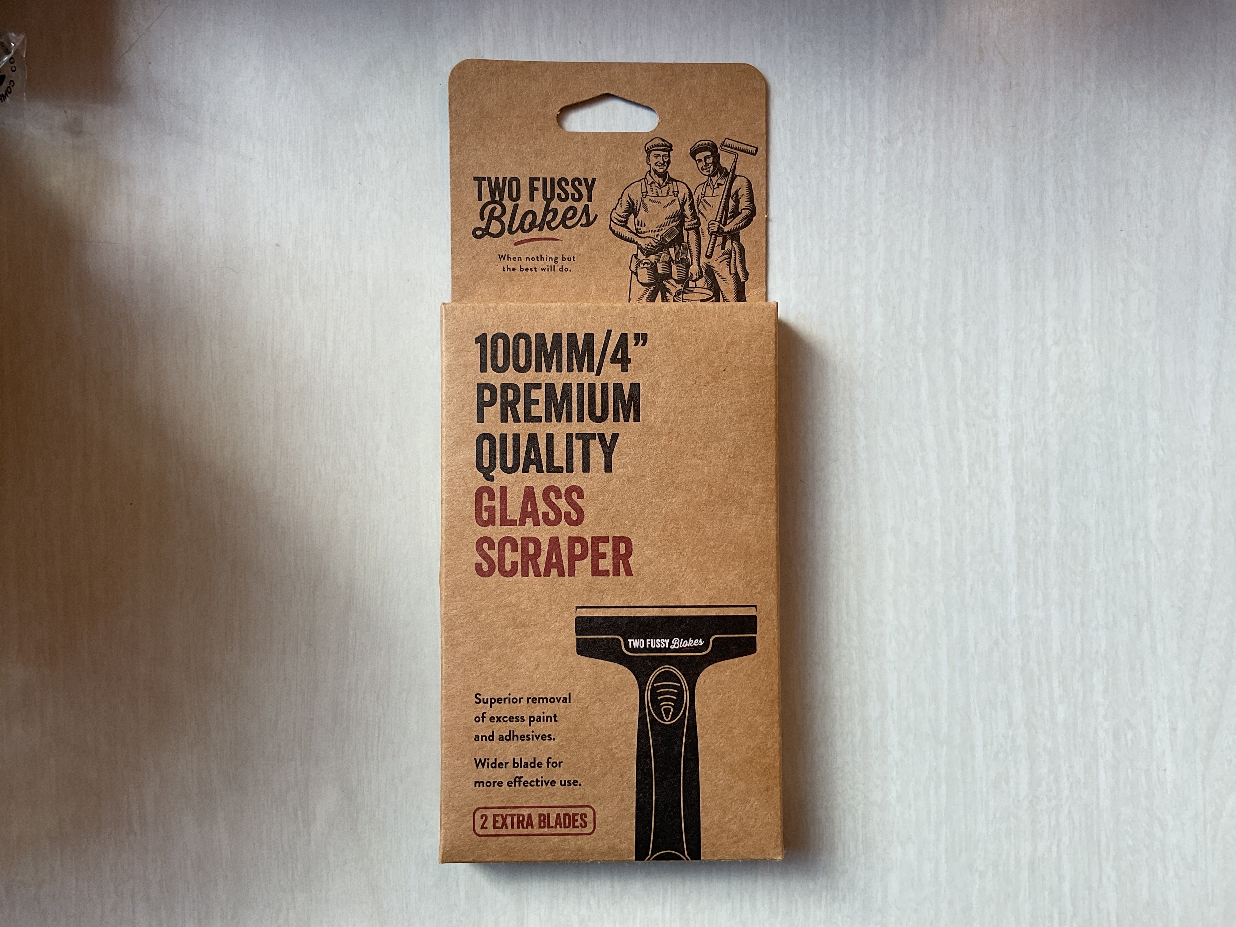 A 100mm quality glass scraper by Two Fussy Blokes, packaged in a cardboard backing with branding and product information.