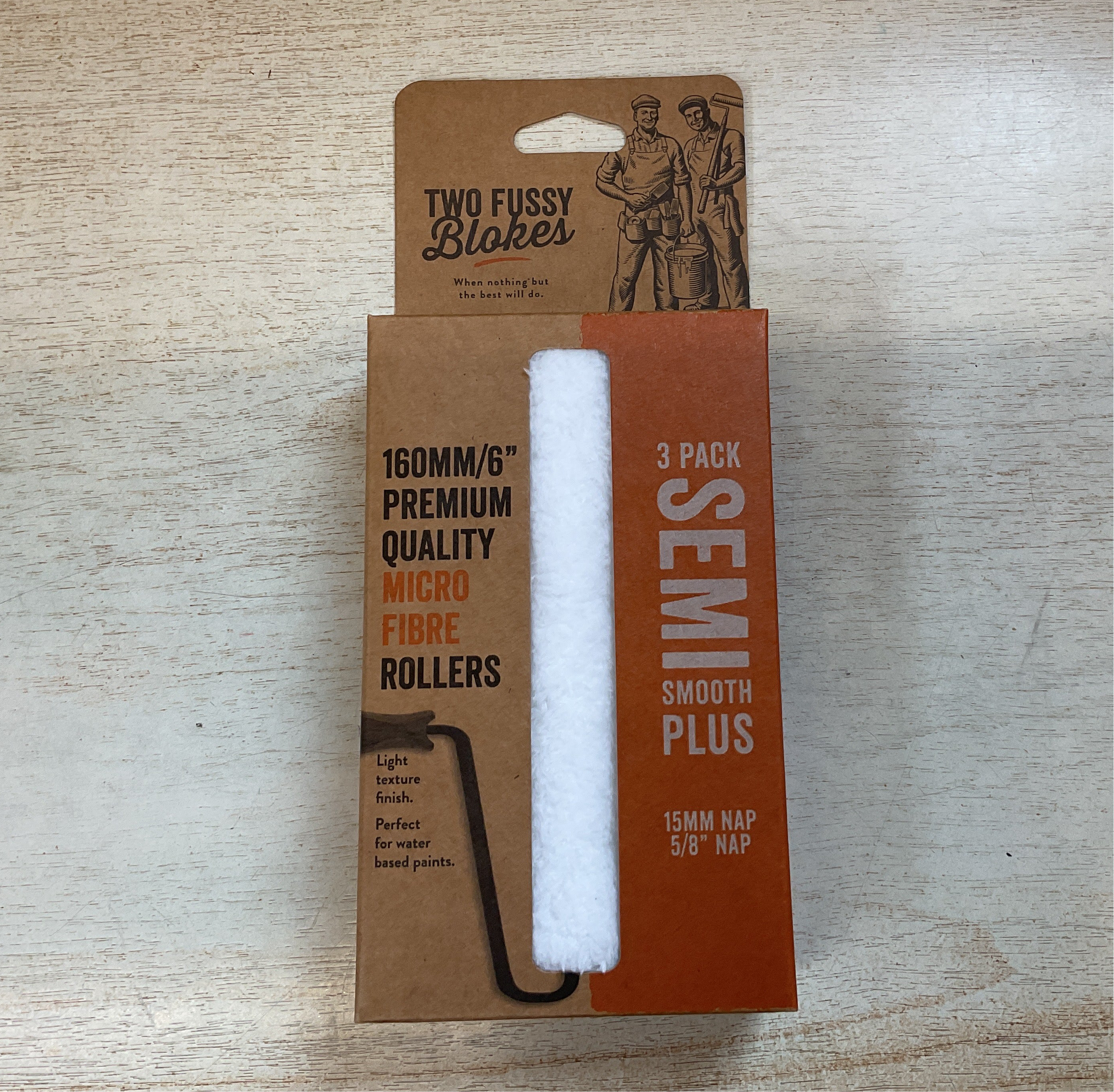 Three-pack of semi-smooth plus microfiber rollers in a cardboard packaging on a wooden surface.