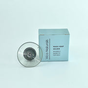 A clear, round soap holder with a magnetic base, displayed in front of its blue packaging box labeled 'Magic Soap Holder'.