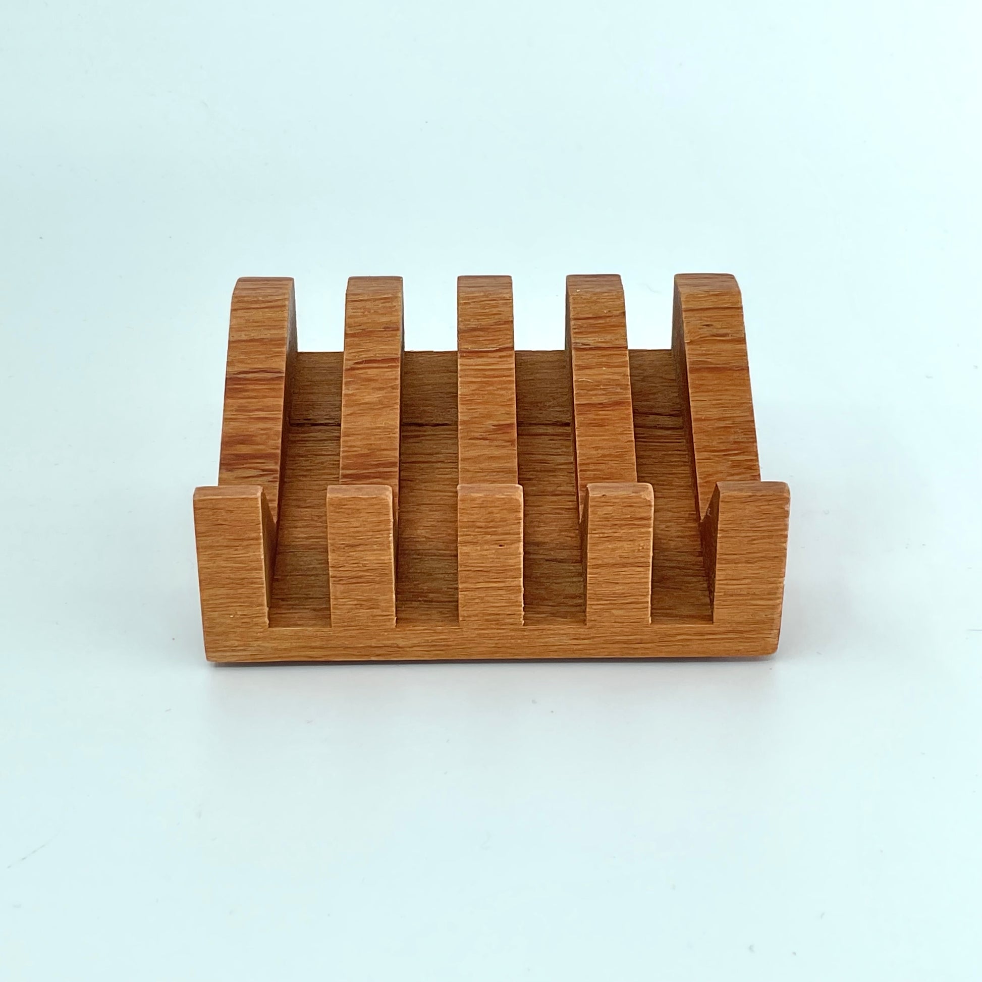 A wooden teak soap dish with wide grooves for drainage, displayed on a white background.