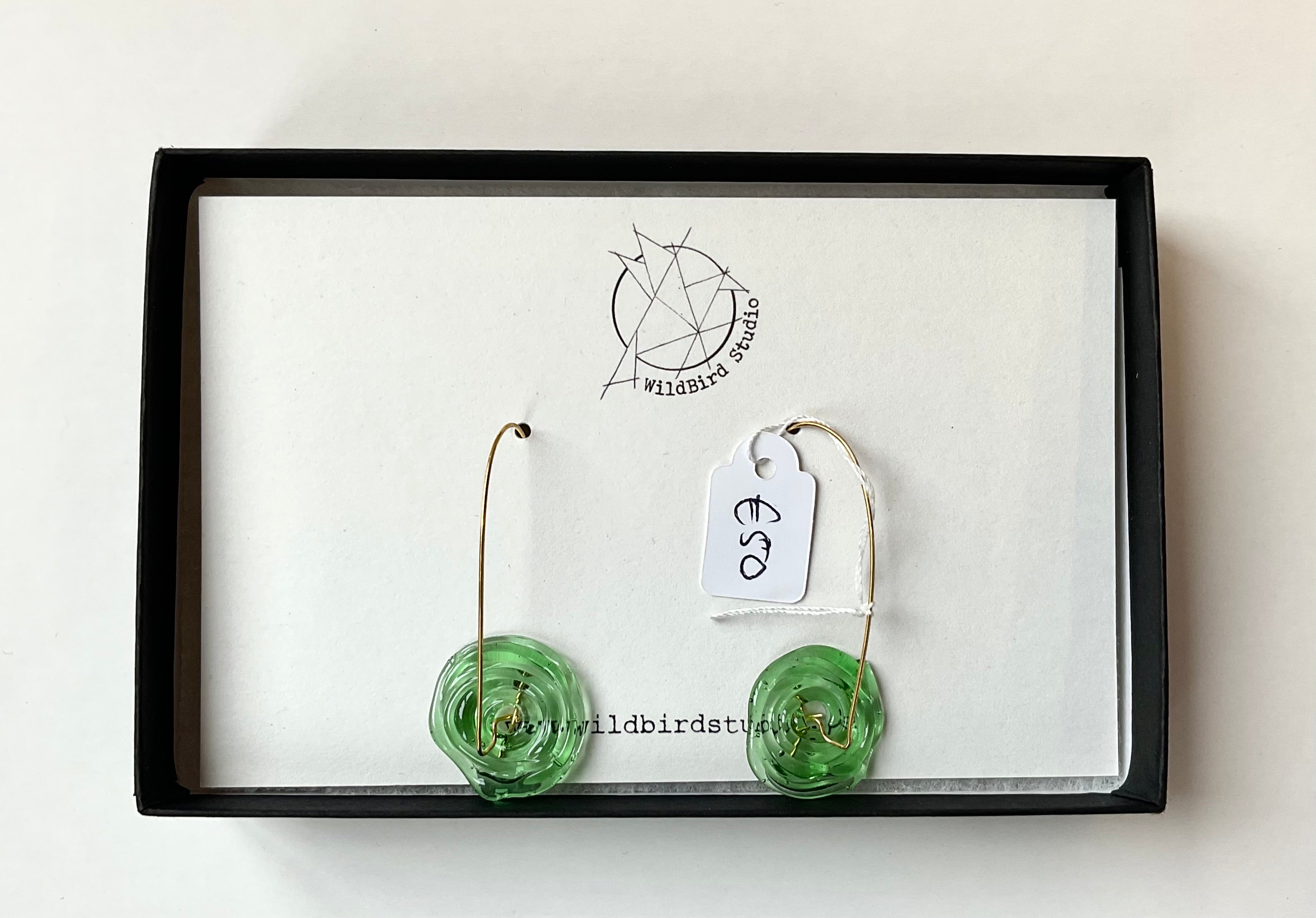 Green earrings on a card with 'Wildbird Studio' branding on a white background