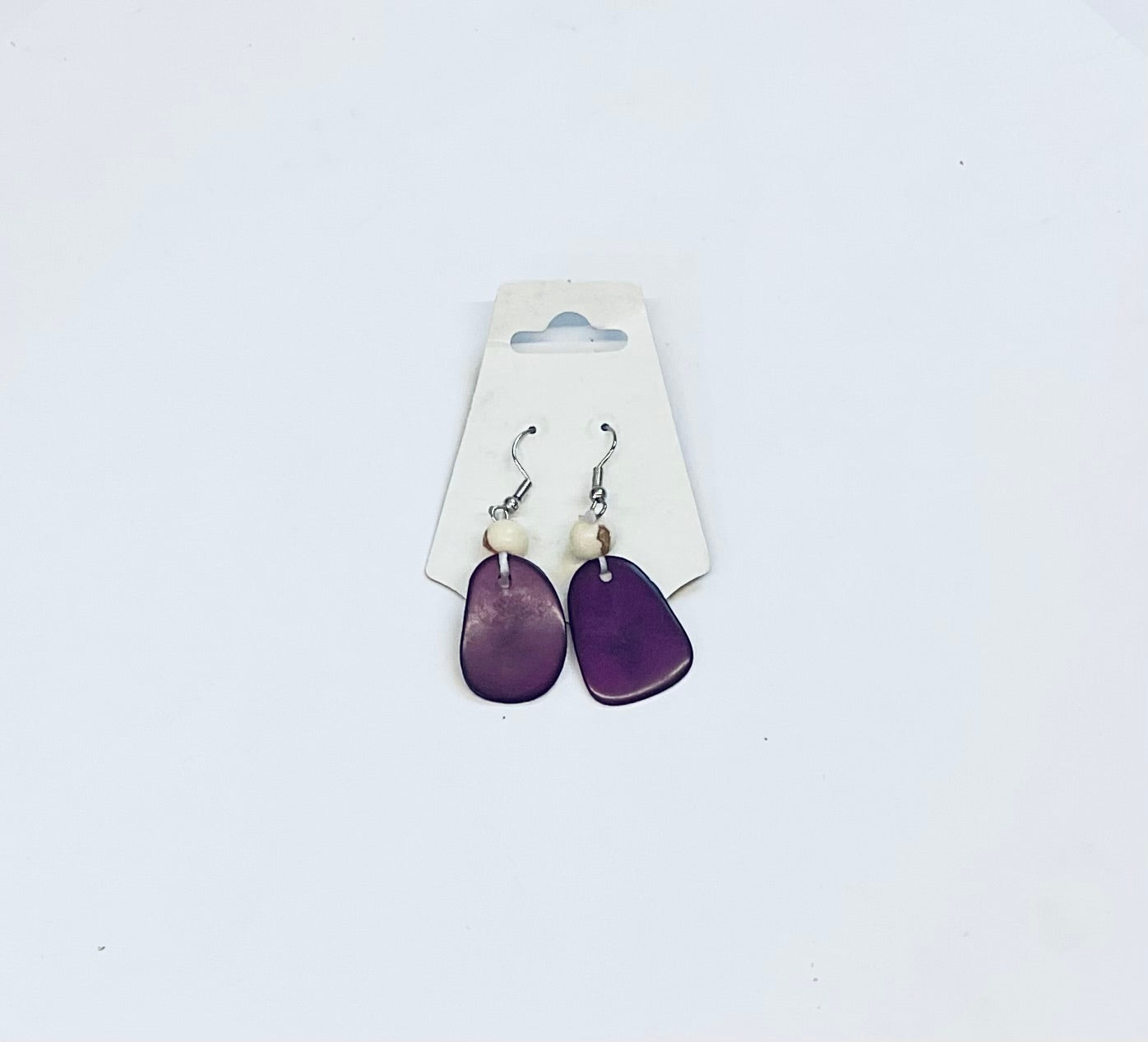 Purple earrings on a white card against a light gray background