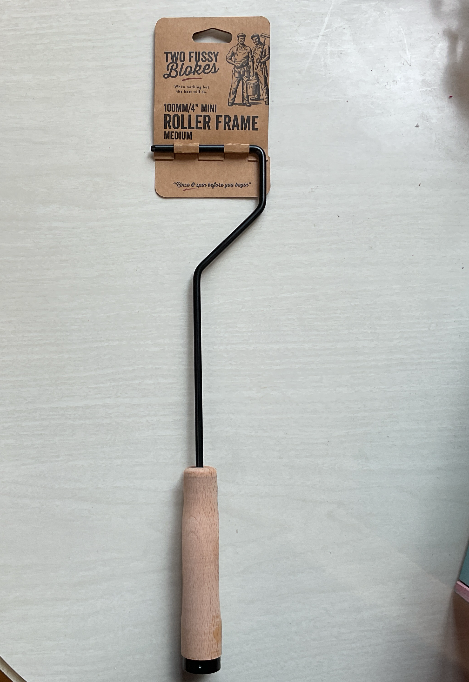 A medium roller frame with a wooden handle and a metal frame, packaged in a cardboard box with the brand name 'Two Fussy Blokes' visible.