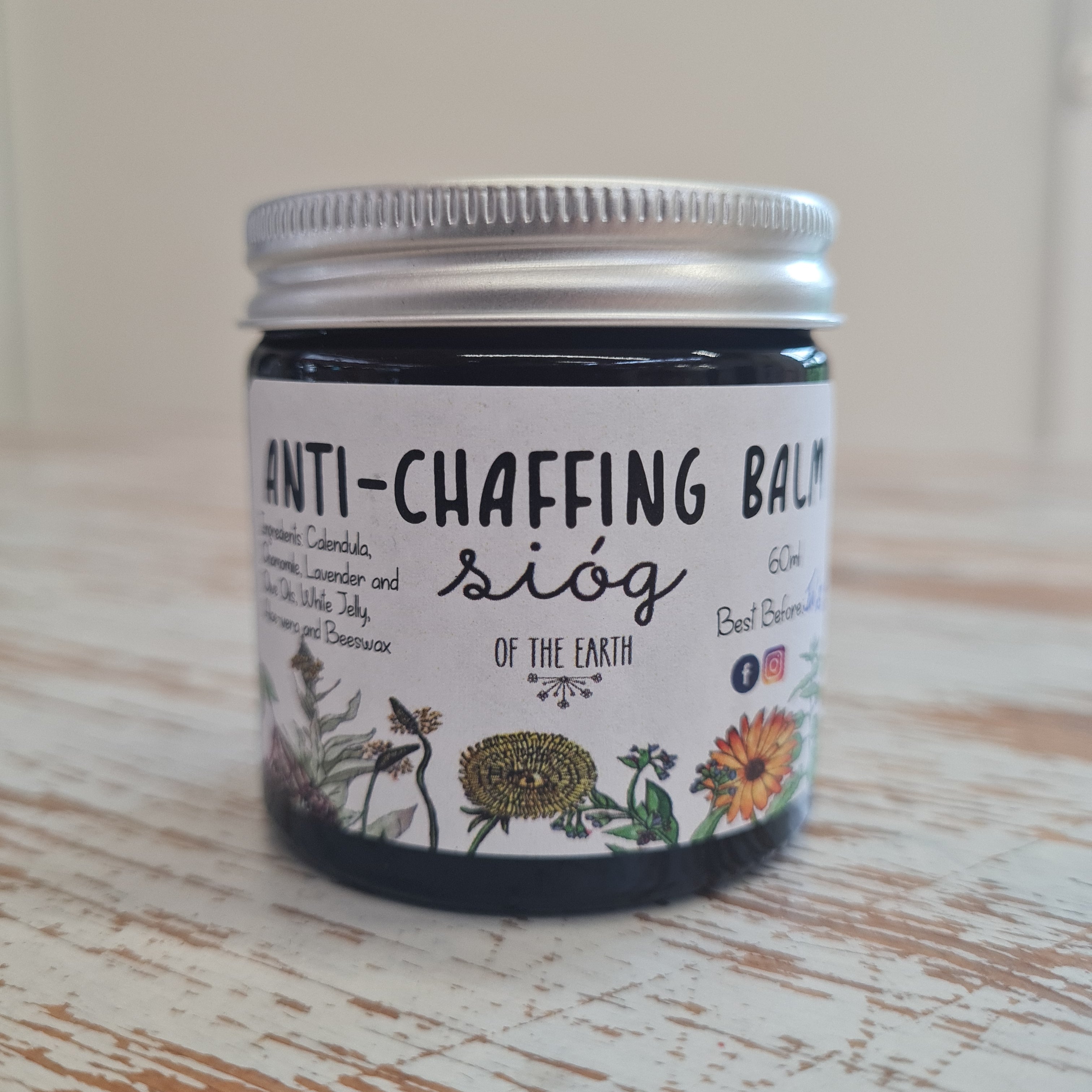 A jar of Sióg of The Earth Anti-Chaffing Balm with a label featuring floral illustrations and text detailing the product name and ingredients such as Aloe Vera, Chamomile, and Lavender.