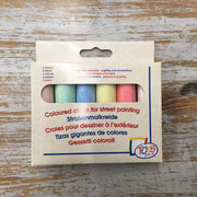 A pack of multi-colored chalk for street painting displayed on a wooden surface.