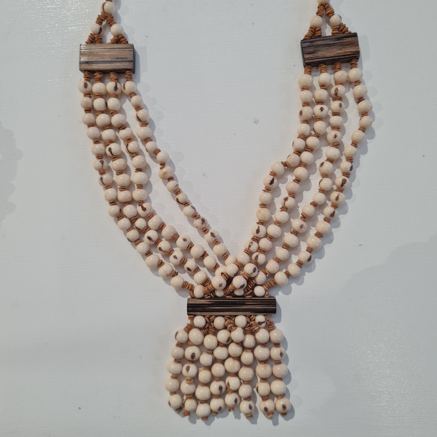 white beaded necklace made from acai seeds